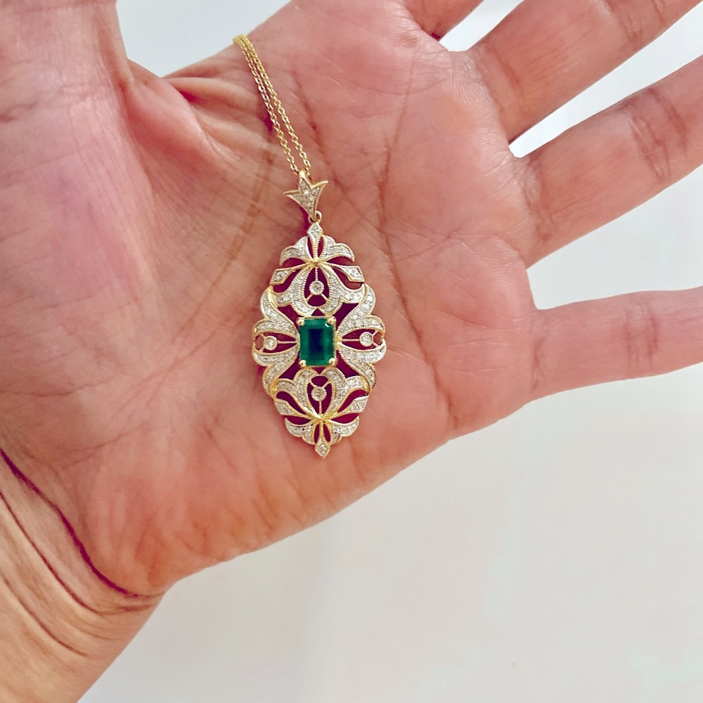 Elegant Emerald, Diamond, and Gold necklace pendant with 14k yellow gold chain.
